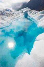 深色高山上的白雪围绕着亮蓝色的冰川湖